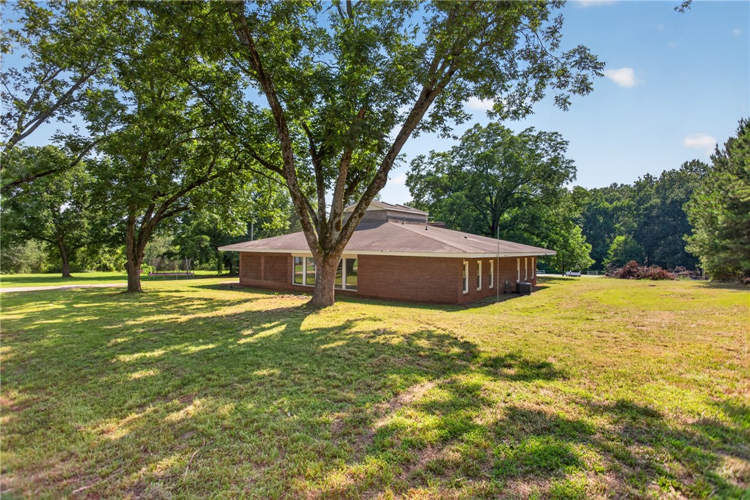 1412 Simpson Road Pendleton, SC 29670 - Photo 42 of 48 Mature trees frame a charming brick residence nestled amidst a spacious, verdant yard.