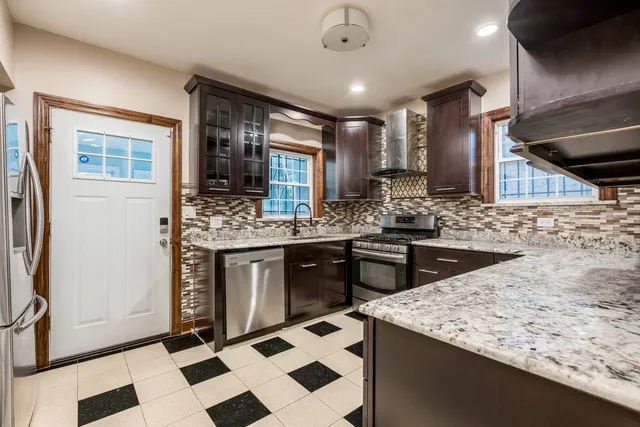 a kitchen with stainless steel appliances kitchen island granite countertop a sink stove and cabinets