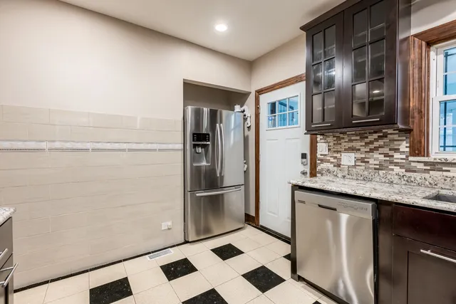 a kitchen with stainless steel appliances granite countertop a refrigerator and a sink
