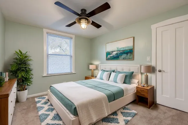 a bedroom with a large bed and a chandelier