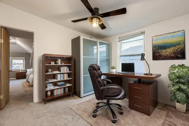 a view of a workspace with furniture and a window
