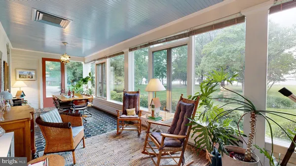 a living room with furniture a fireplace and a large window with wooden floor