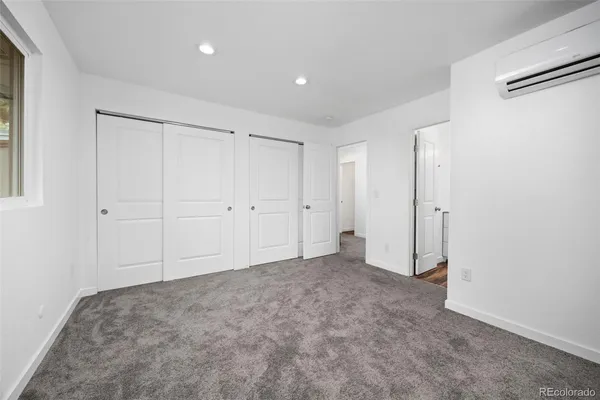 a bathroom with a granite countertop toilet a sink and a mirror