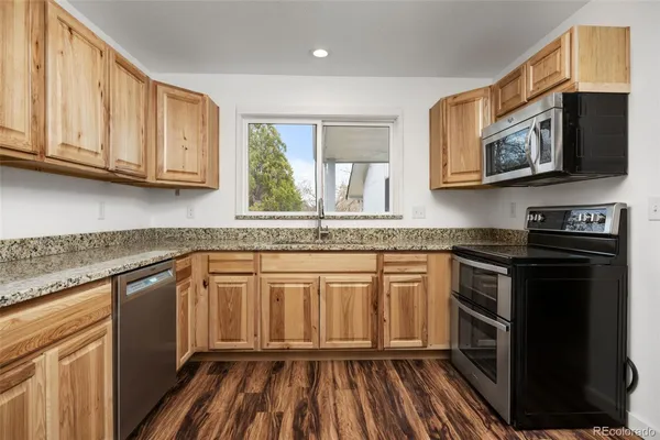 a kitchen with granite countertop white cabinets and stainless steel appliances