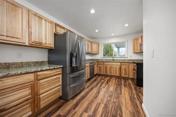 a spacious bedroom with a bed and wooden floor