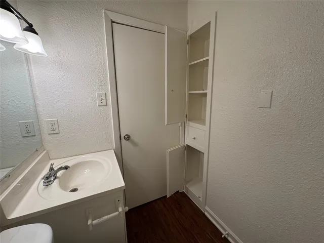 a big room with wooden floor a chandelier fan and windows