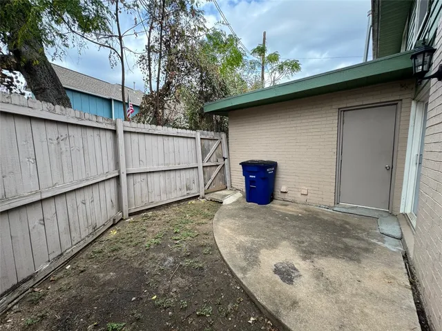 a view of a house with a backyard and wooden fence