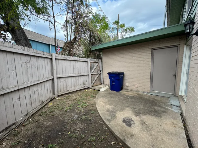 a view of a house with a backyard and wooden fence