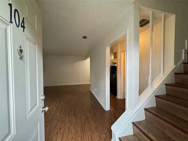 a view of a hallway with wooden floor and staircase