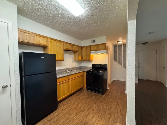 a kitchen with granite countertop a refrigerator and a stove