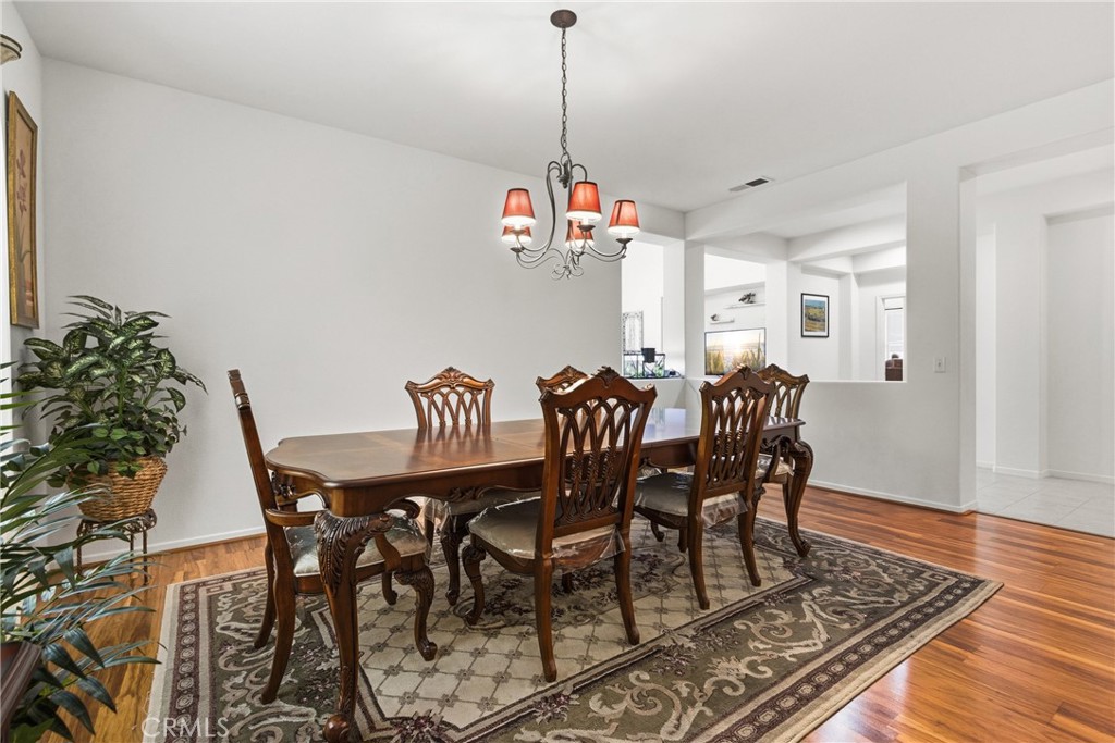 33145 Vermont Road Temecula, CA 92592 - Photo 7 of 41 a view of a dining room and livingroom with furniture wooden floor a chandelier