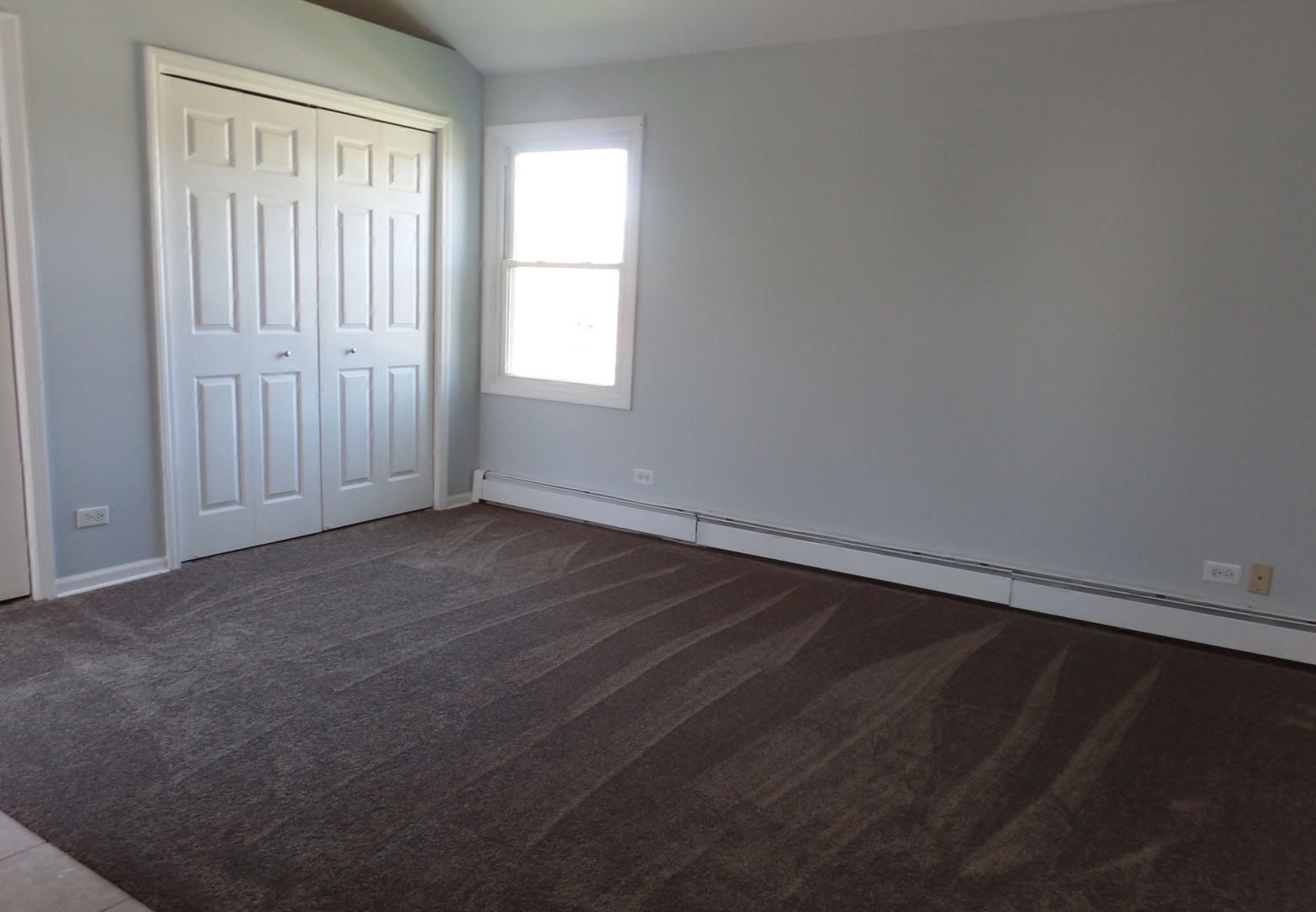 1504 Comanche Drive Bolingbrook, IL 60490 - Photo 27 of 34 an empty room with wooden floor and windows with curtains