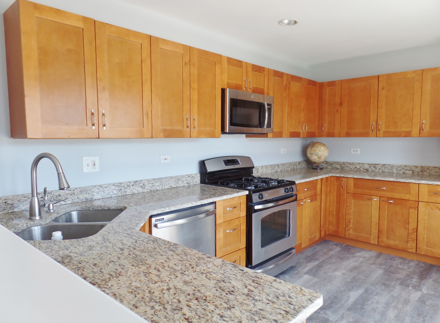 1504 Comanche Drive Bolingbrook, IL 60490 - Photo 8 of 34 a kitchen with stainless steel appliances granite countertop a sink stove and microwave