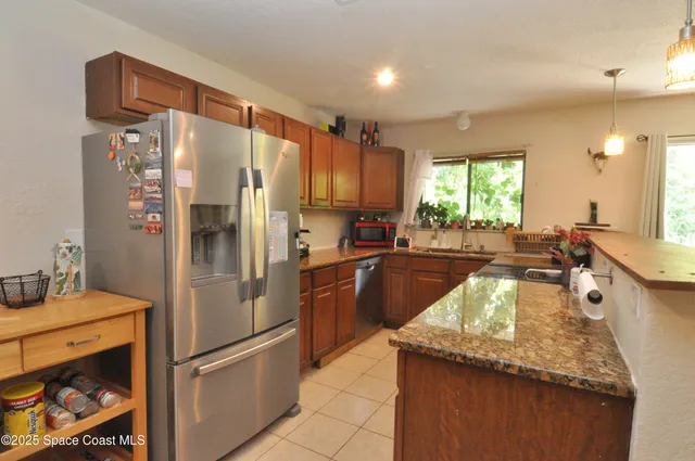 a kitchen with granite countertop a refrigerator and a sink