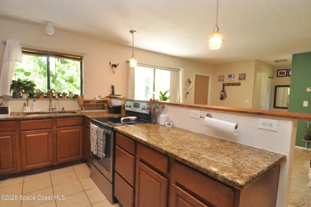 a kitchen with stainless steel appliances granite countertop a sink counter space cabinets and a large window