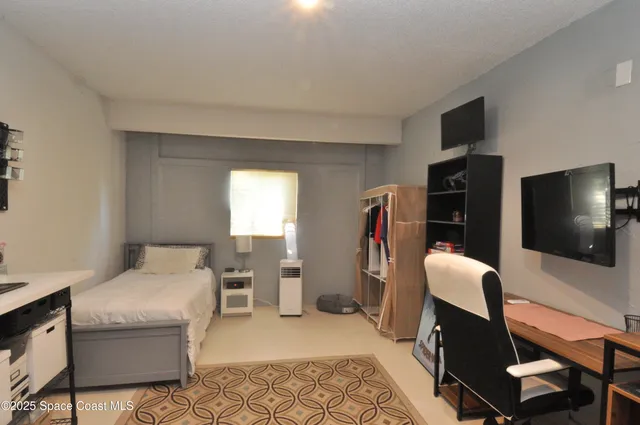 a living room with furniture a flat screen tv and a window