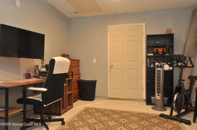 a view of a workspace with furniture and a flat screen tv