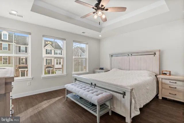 a bedroom with a bed next to a window and a chandelier