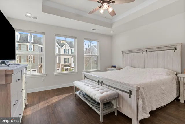 a bed sitting in a spacious bedroom next to a window