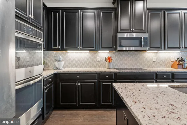 a kitchen with stainless steel appliances granite countertop a sink and a refrigerator