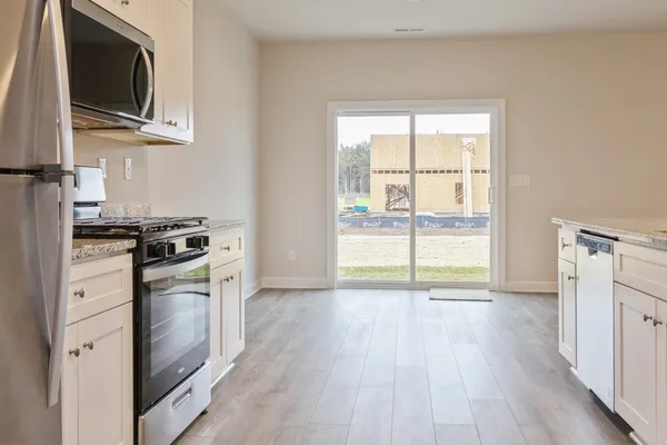a kitchen with a stove a microwave and wooden floor
