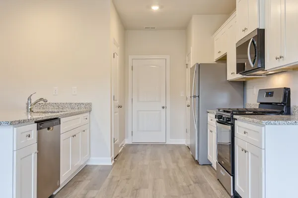a kitchen with stainless steel appliances granite countertop a stove and a refrigerator