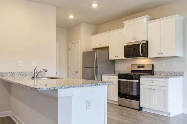 a kitchen with stainless steel appliances granite countertop a sink and a stove
