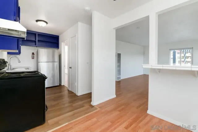 a kitchen with a refrigerator and a stove top oven