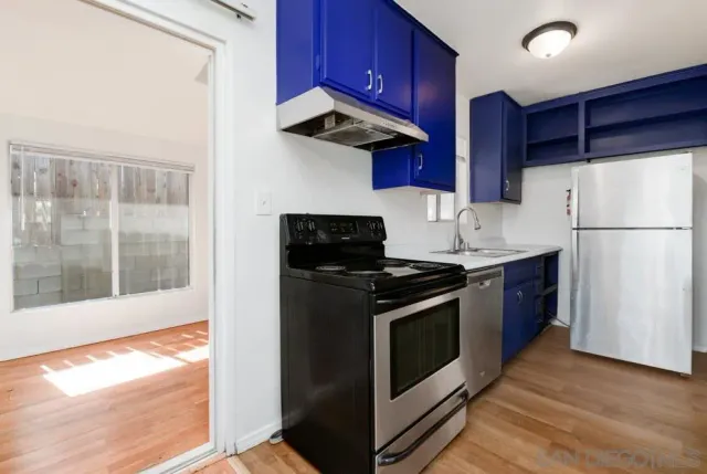 a kitchen with stainless steel appliances granite countertop a stove a refrigerator and a wooden cabinets