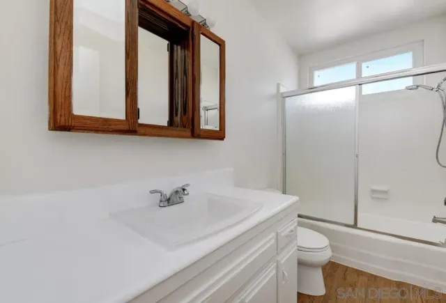 a bathroom with a sink a toilet and shower