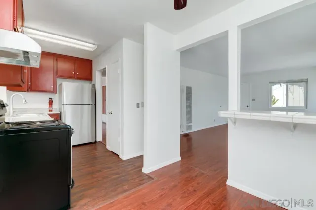 a kitchen with a refrigerator and a stove top oven