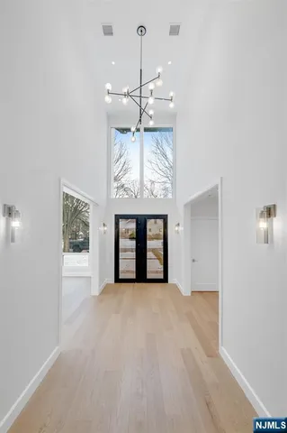 a view of an empty room with a chandelier fan and a window