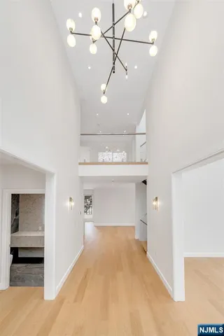 a view of a livingroom with a fireplace a chandelier and windows