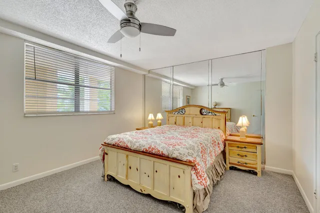 a bedroom with a bed next to a window and a chandelier