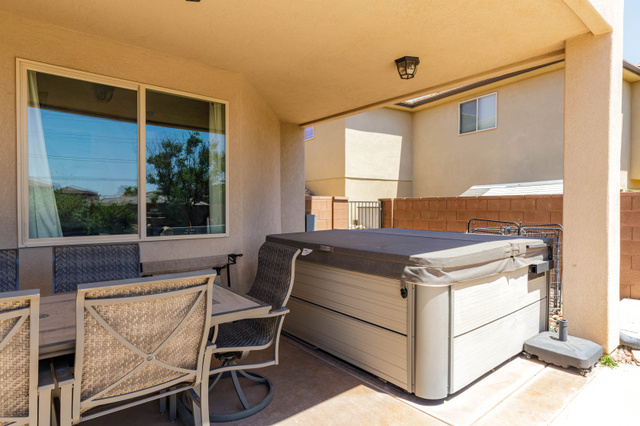2005 West 450 S Circle St. George, UT 84770 - Photo 38 of 57 Covered patio with a built-in spa, concrete flooring, and an exterior light fixture