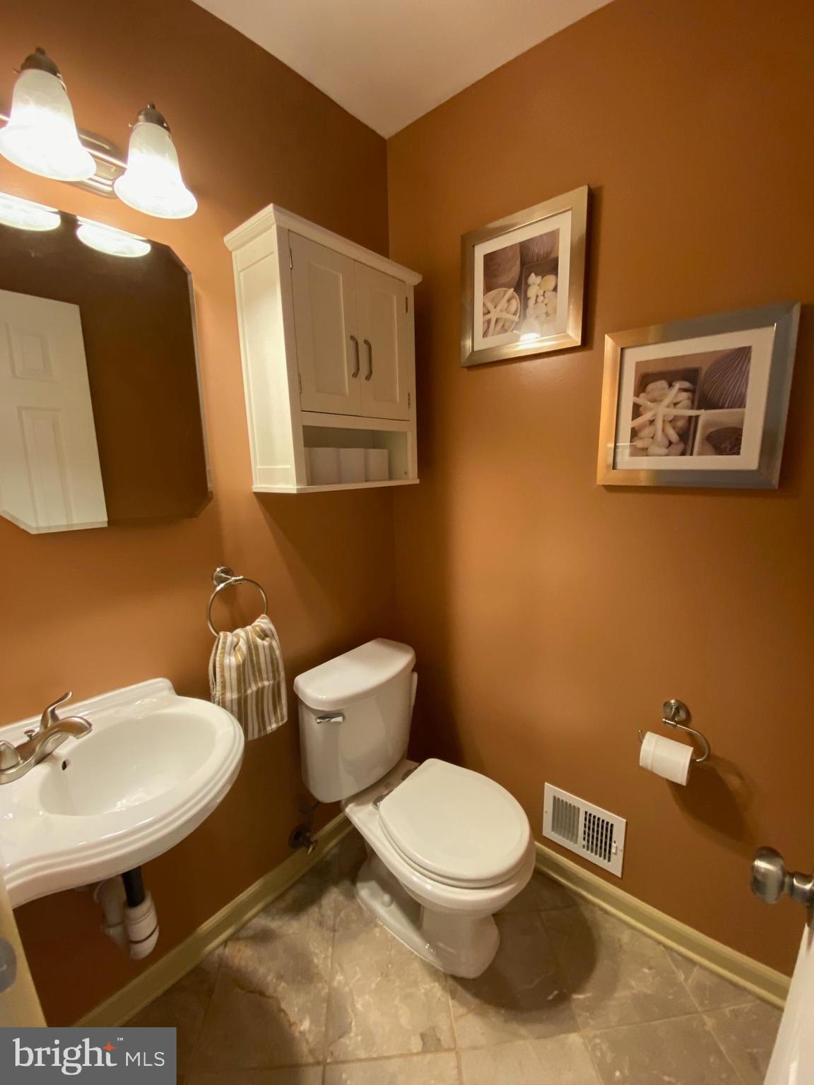 15918 Jerald Road Laurel, MD 20707 - Photo 33 of 40 a bathroom with a toilet a sink and mirror
