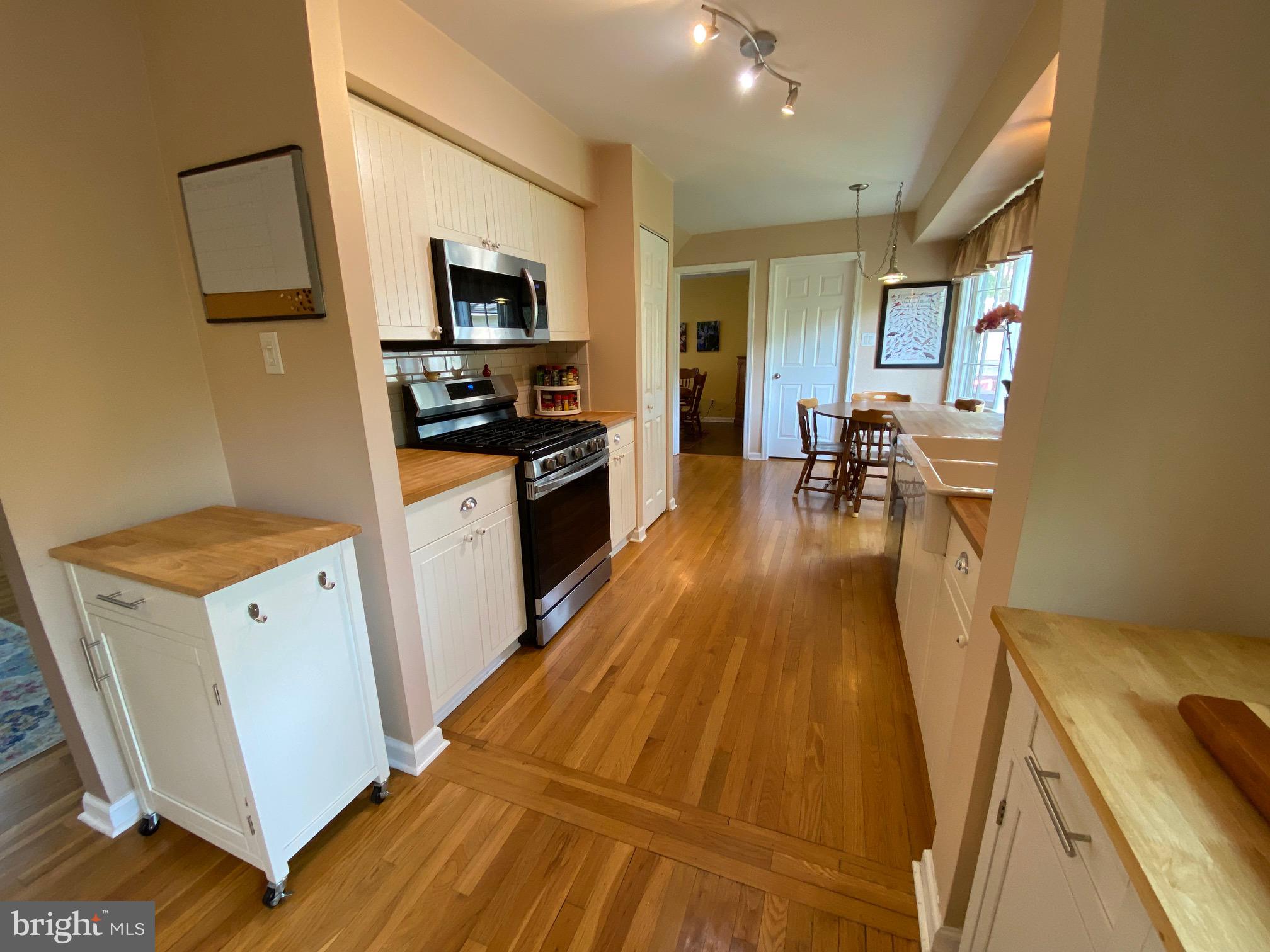 15918 Jerald Road Laurel, MD 20707 - Photo 6 of 40 a kitchen with wooden floor and stainless steel appliances