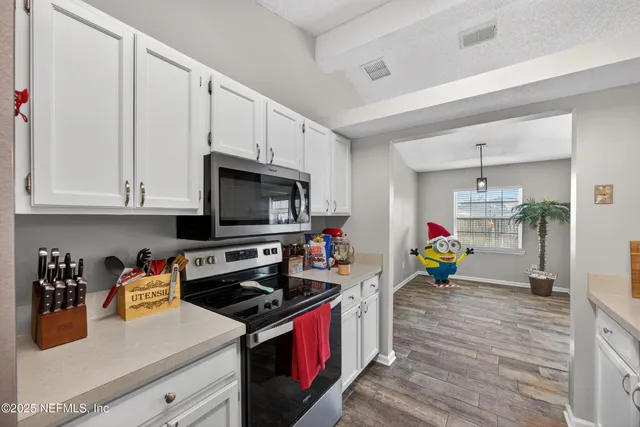 a kitchen that has a lot of cabinets and appliances