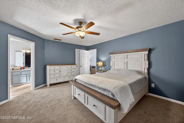 a spacious bedroom with a bed and a chandelier