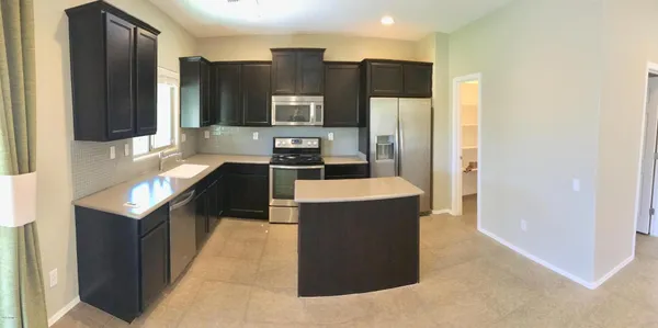 a kitchen with stainless steel appliances granite countertop a refrigerator a stove and a sink