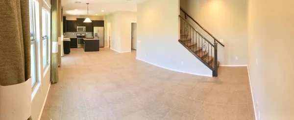 a view of a hallway with wooden floor and a living room