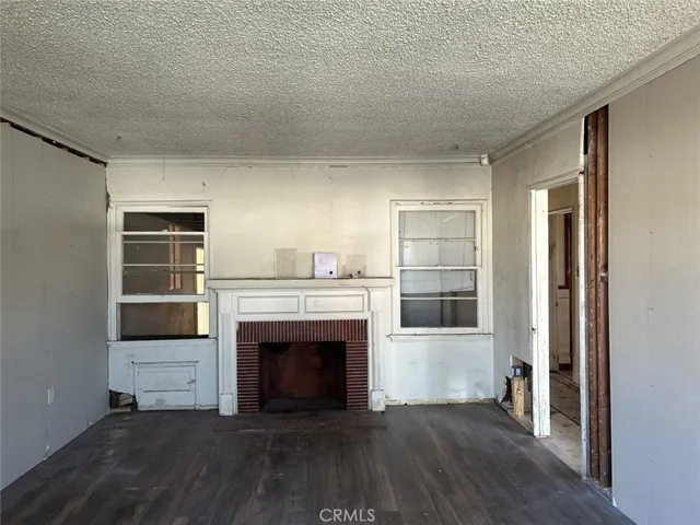 a view of a livingroom with a fireplace and wooden floor