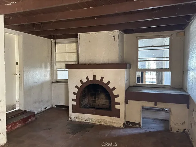 a living room with a fireplace windows and a fireplace