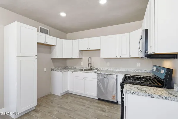a kitchen with stainless steel appliances granite countertop a stove and a refrigerator