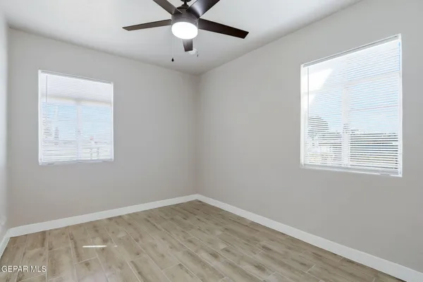 en empty room with wooden floor and windows
