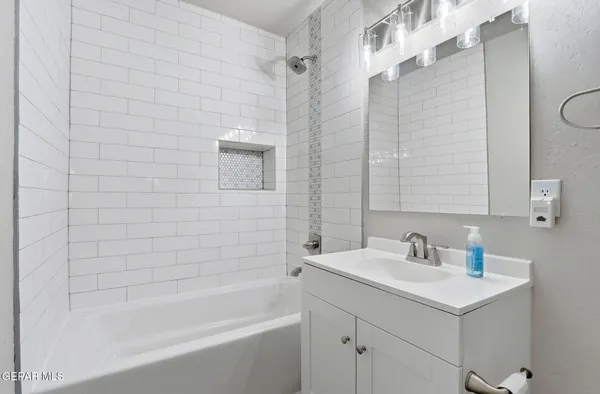 a bathroom with a shower sink vanity and mirror