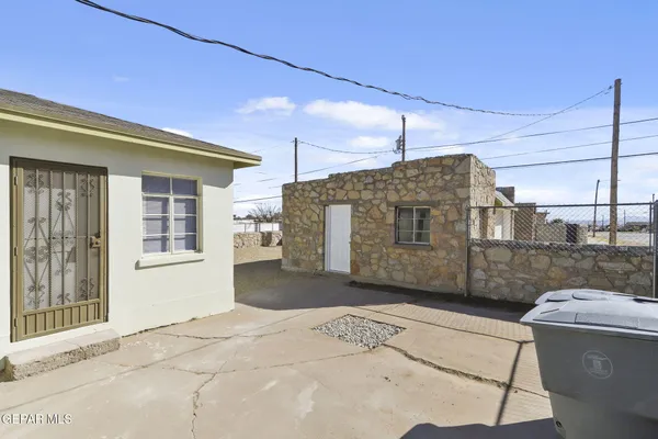 a view of a house with a floor to ceiling window and wooden fence
