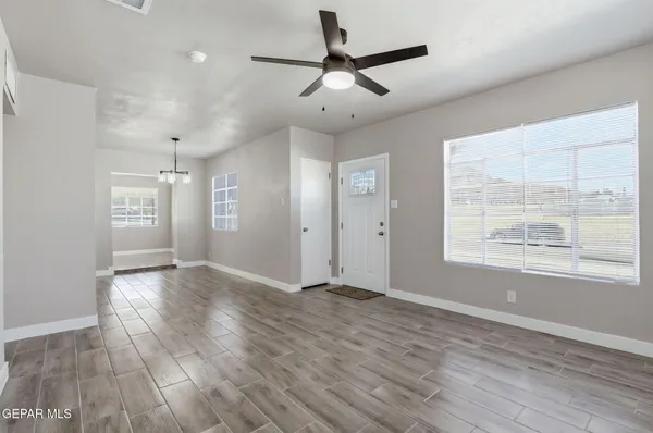 a view of an empty room with window and wooden floor
