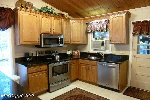 155 Chipmunk Road Bushkill, PA 18324 - Photo 5 of 18 a kitchen with stainless steel appliances granite countertop a stove a sink and a microwave