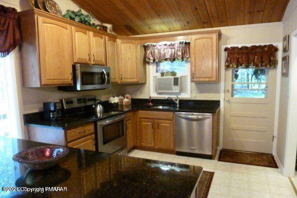 155 Chipmunk Road Bushkill, PA 18324 - Photo 6 of 18 a kitchen with stainless steel appliances granite countertop a stove a sink and a microwave